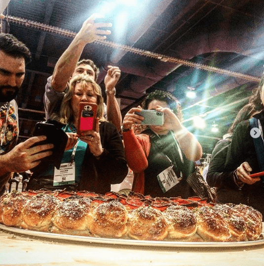 group of people taking photos of a pizza